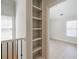 Hallway featuring a built-in bookcase, railing, and an entrance into a bedroom with lots of natural light at 5210 Davenport Pl, Roswell, GA 30075