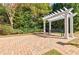 Charming brick patio area with pergola and bench surrounded by lush greenery at 5210 Davenport Pl, Roswell, GA 30075