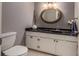 Well-lit half bathroom with modern fixtures, granite counters, and a decorative round mirror at 58 Basswood Cir # 29, Atlanta, GA 30328