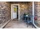 Welcoming entrance with open door, stone facade, and decorative outdoor seating area at 58 Basswood Cir # 29, Atlanta, GA 30328