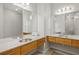 Modern bathroom with double vanity with granite countertop, wood cabinets, tile floors, large mirrors, and vanity lighting at 1430 Dresden Ne Dr # 215, Atlanta, GA 30319