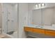 Modern bathroom with glass enclosed shower, granite countertop, wood cabinets, tile floors, and a large mirror with vanity lighting at 1430 Dresden Ne Dr # 215, Atlanta, GA 30319