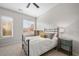 Cozy bedroom with carpet, neutral walls, large windows with blinds, ceiling fan, a metal bed frame, and two side tables at 1430 Dresden Ne Dr # 215, Atlanta, GA 30319