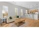 Bright living room with hardwood floors, sofa, area rug, large windows, and an open floorplan with the kitchen and breakfast bar at 1430 Dresden Ne Dr # 215, Atlanta, GA 30319
