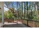View from a wooden back deck with railings, overlooking a natural wooded backyard at 165 River Ridge Ln, Roswell, GA 30075