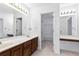 Bright bathroom featuring double sinks and a vanity area, as well as a view into a large closet at 165 River Ridge Ln, Roswell, GA 30075