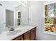 Bathroom featuring a marble countertop vanity, a large mirror, and a window for natural light at 165 River Ridge Ln, Roswell, GA 30075