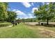 Community grills and picnic tables for use next to a beautiful waterfont with lush trees in the background at 165 River Ridge Ln, Roswell, GA 30075