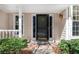Welcoming front entrance with decorative door, sidelight windows, and mature landscaping at 165 River Ridge Ln, Roswell, GA 30075