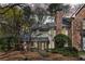 View of the exterior of the home with brick and siding and mature trees at 165 River Ridge Ln, Roswell, GA 30075