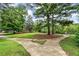 A lawn of manicured grass with walkways and many canoes and kayaks neatly displayed on a rack in the background at 165 River Ridge Ln, Roswell, GA 30075