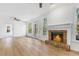 Bright living room with hardwood floors, a brick fireplace, and views of the back deck at 165 River Ridge Ln, Roswell, GA 30075