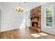 Inviting living room with a brick fireplace, natural light from windows, and hardwood floors at 165 River Ridge Ln, Roswell, GA 30075