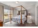 Bright bedroom with a four-poster bed and large window overlooking the landscaped backyard at 2033 Lee Se Rd, Smyrna, GA 30080