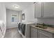 Functional laundry room with modern machines, ample cabinet space, and a utility sink at 2033 Lee Se Rd, Smyrna, GA 30080