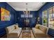 Stylish navy-blue living room with a crystal chandelier, elegant furniture and natural light at 2033 Lee Se Rd, Smyrna, GA 30080