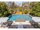 Beautiful backyard pool with stone patio, lounge chairs, and lush landscaping for serene relaxation at 2033 Lee Se Rd, Smyrna, GA 30080