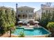Backyard with pool features a lounge area, patio with seating, landscaping, and mature trees at 2033 Lee Se Rd, Smyrna, GA 30080