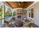 Relaxing covered porch featuring a brick fireplace and comfortable seating for outdoor enjoyment at 2033 Lee Se Rd, Smyrna, GA 30080