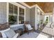 Inviting front porch with comfortable wicker chairs, pillows and a wooden ceiling at 2033 Lee Se Rd, Smyrna, GA 30080