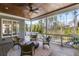 Inviting covered porch with wood ceiling, ceiling fan, and comfortable seating overlooking lush greenery at 2033 Lee Se Rd, Smyrna, GA 30080