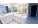 Bright bathroom featuring a large mirror, a functional vanity and fixtures, and walk-in closet access at 3185 Haverhill Rowe, Lawrenceville, GA 30044