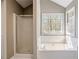 Bathroom showcasing a shower and a soaking tub near a bright window at 2072 Arbor Forest Sw Dr, Marietta, GA 30064