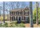 Charming two-story home featuring a symmetrical facade, black shutters, and a well-maintained front yard with mature trees at 2072 Arbor Forest Sw Dr, Marietta, GA 30064