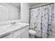 Clean bathroom featuring a single vanity, toilet, and shower with a unique curtain at 469 Ralph Still Rd, Dacula, GA 30019