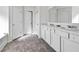 Bright bathroom featuring double sinks, a large mirror, and stylish gray tile flooring at 469 Ralph Still Rd, Dacula, GA 30019