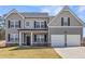 Traditional two-story home featuring gray siding, black shutters, well-manicured lawn, and an attached two-car garage at 469 Ralph Still Rd, Dacula, GA 30019