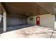 Spacious carport featuring a painted brick wall, access door, and covered parking area with a bright red door at 399 W Sandtown Sw Rd, Marietta, GA 30064