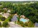 Aerial view showcasing a sparkling community pool, amenity center, playground, and ample parking at 4020 Inman Park Lane, Buford, GA 30519
