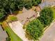Aerial view of a two story brick home with a well maintained yard, driveway and mature trees at 4020 Inman Park Lane, Buford, GA 30519