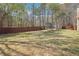 An expansive backyard with a trampoline, wooden fence, and mature trees providing shade at 4020 Inman Park Lane, Buford, GA 30519