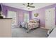 Bright bedroom with dual windows, carpet, and lavender walls providing natural light, and a cozy, comfortable setting at 4020 Inman Park Lane, Buford, GA 30519