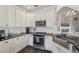 Updated kitchen features white cabinets, stainless steel appliances, farmhouse sink, and dark countertops at 4020 Inman Park Lane, Buford, GA 30519