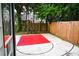 Backyard with a red basketball court surrounded by a wooden fence and trees at 811 Heritage Valley Rd, Norcross, GA 30093