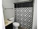 A small bathroom with a toilet and a black and white shower curtain at 811 Heritage Valley Rd, Norcross, GA 30093