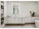 Bright bathroom with marble floors, modern cabinets, an illuminated mirror and a view to the soaking tub at 2520 Peachtree Rd # 602, Atlanta, GA 30305