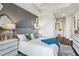 Brightly lit bedroom with wood floors, modern gray accent wall, and three decorative mirrors at 2520 Peachtree Rd # 602, Atlanta, GA 30305