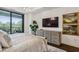 Bright main bedroom with balcony access, hardwood floors, and a stylish dresser under the mounted TV at 2520 Peachtree Rd # 602, Atlanta, GA 30305