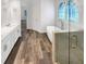 Elegant bathroom featuring a soaking tub, a glass shower, dual sinks, and wood-look tile flooring at 3083 Milledge Gate Se Ct, Marietta, GA 30067