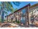 Charming two-story brick townhouse with shuttered windows, a black door, and mature trees at 748 Garden View Dr, Stone Mountain, GA 30083