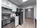 A view of the kitchen with a black stove and refrigerator along with a cookbook on the marble countertop at 748 Garden View Dr, Stone Mountain, GA 30083