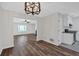 Open-concept dining area featuring a modern light fixture and wood-look flooring that flows seamlessly into the living room at 219 Holcomb Ferry Rd, Roswell, GA 30076