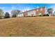 Exterior view of townhomes featuring a grassy lawn and blue sky at 219 Holcomb Ferry Rd, Roswell, GA 30076