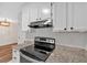 Close up of kitchen with stainless steel appliances, granite counters, and white cabinets with updated black pulls at 219 Holcomb Ferry Rd, Roswell, GA 30076
