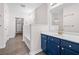 Bathroom with a blue vanity with white countertop, and a walk-in closet in the background at 1955 Nocturne Dr # 3301, Alpharetta, GA 30009