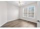 A bright bedroom has wood-look floors, a window, and neutral walls at 1955 Nocturne Dr # 3301, Alpharetta, GA 30009